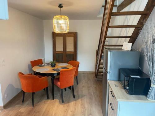 - une salle à manger avec une table et des chaises orange dans l'établissement La Maisonnette des Grèves, 8 min du Mont St Michel, à Courtils