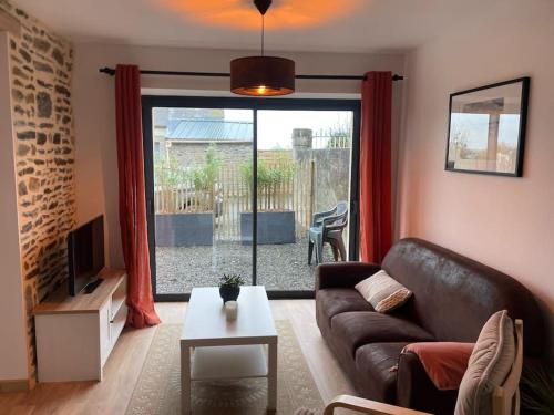 un salon avec un canapé et une table dans l'établissement La Maisonnette des Grèves, 8 min du Mont St Michel, à Courtils