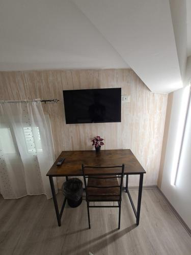 a room with a table and a television on a wall at Le Querce in Spianate