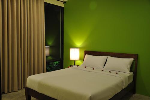 Dormitorio verde con cama con pared verde en Udee Bangkok Hostel en Bangkok