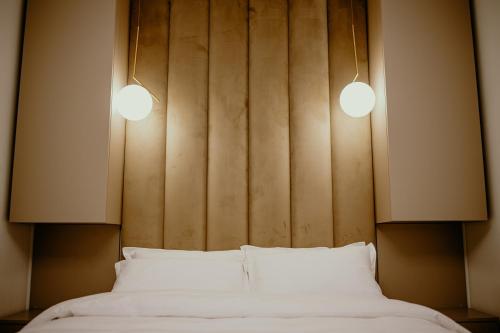 a bedroom with two white beds and two lights at Best House in Botoşani