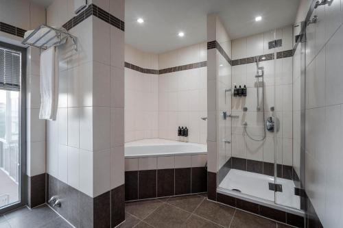 a bathroom with a shower and a bath tub at Eurostars Queen of Montenegro in Budva