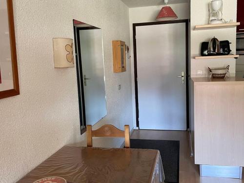 une chambre avec une table et une porte menant à une cuisine dans l'établissement 2 pièces pour 4 pers avec balcon sud, garage et linge de lit inclus - FR-1-263-166, à Valloire
