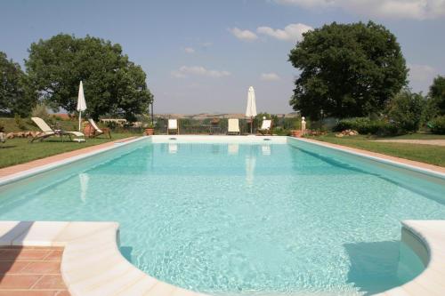 uma grande piscina com água azul em Agriturismo Renaccino em Siena