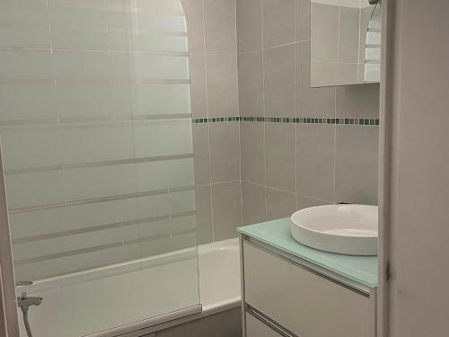 une salle de bain blanche avec un lavabo et une douche dans l'établissement 2 pièces pour 4 pers avec balcon sud, garage et linge de lit inclus - FR-1-263-166, à Valloire