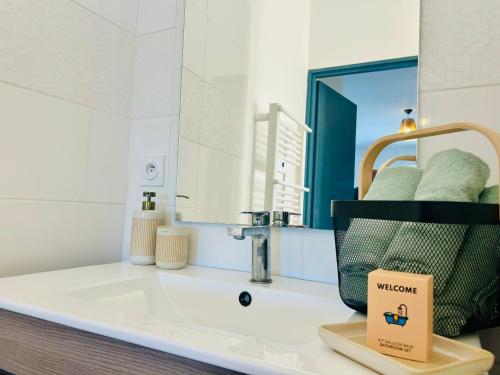 une salle de bain avec un lavabo et un miroir dans l'établissement Le Clos des Flots Proche plages et centre ville, à Carqueiranne