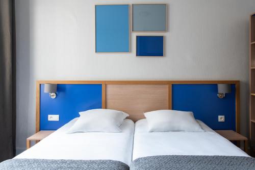 two beds sitting next to each other in a bedroom at Est Hotel in Paris