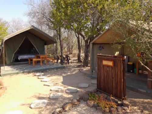 a tent with a table and a picnic table in front at Little5 Camp in Hoedspruit