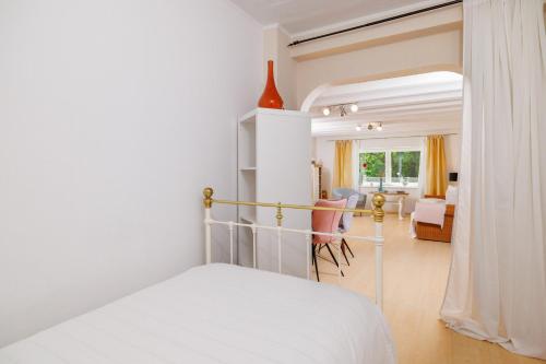 Un dormitorio blanco con una cama y una sala de estar. en Emaris, en Tribalj