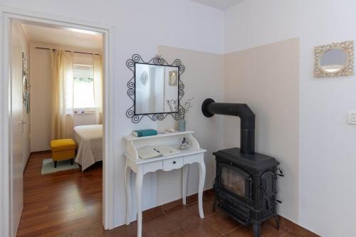 Habitación con estufa de leña y espejo. en Emaris, en Tribalj