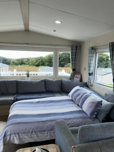 a living room with a couch and a large window at 22 Stowford Gardens Combe Martin in Combe Martin