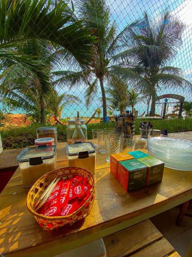 un tavolo con piatti e ciotole con palme di Raio de Sol Residence a Canoa Quebrada