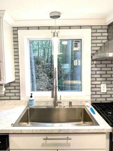 a kitchen with a stainless steel sink and a window at Lakefront Cottage on Brewer Lake in Holden