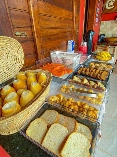 a buffet filled with trays of bread and other foods at ASAS DEL MAR - SUITES in Canoa Quebrada
