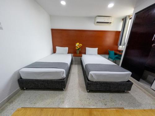 two beds in a small room with at Hotel Caribe Plaza Barranquilla in Barranquilla