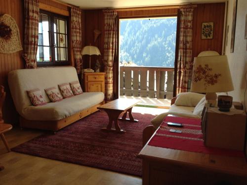 d'un salon avec un canapé et un balcon. dans l'établissement Appartement cosy 2 pièces 5 pers à Châtel, proche des remontées et centre village - FR-1-676-1, à Châtel