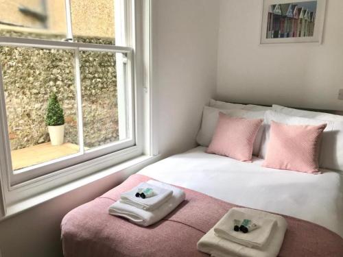 a bedroom with a bed with two towels and a window at Brighton 2 Bed 2 Bath & Terrace in Brighton & Hove