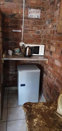 a kitchen with a counter with a microwave and a refrigerator at Koos se Tonteldoos in Mokopane
