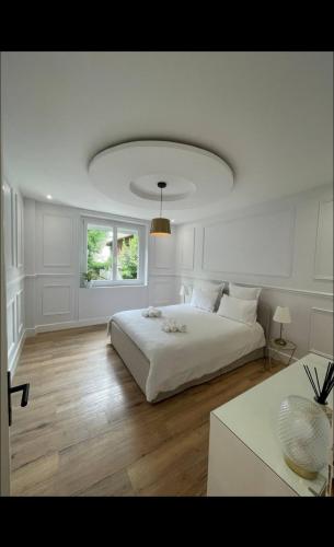 une chambre blanche avec un grand lit et une fenêtre dans l'établissement Villa T5 avec Jacuzzi proche centre ville Darcy, à Dijon