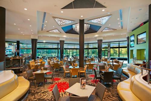 a restaurant with tables and chairs and windows at City Golf Club Motel in Toowoomba