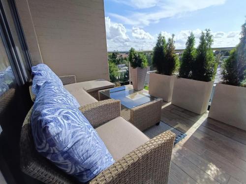 a balcony with couches and a table and potted plants at Apartamenty Relaks & Spa Pięć Mórz in Sianozety
