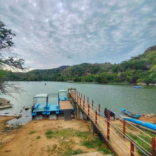 a dock on a river with two boats on it at The White House Resort in Wellawaya
