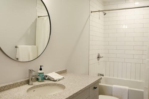 a white bathroom with a sink and a mirror at Beachview getaway at the New Carlyle 202 on the Main strip in Grand Bend in Grand Bend