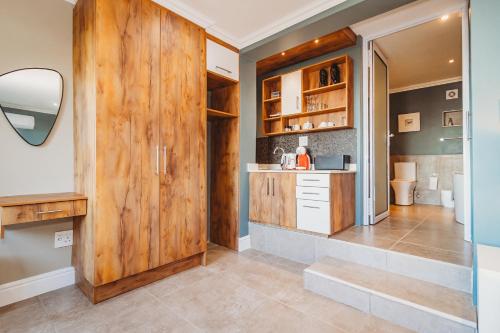 ウィルダネスにあるUnder the Boardwalk B&B Guest Houseの木製のドアとカウンター付きのキッチン