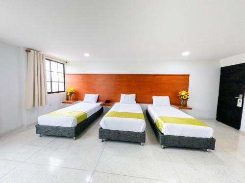 a bedroom with two beds in a room at Hotel Caribe Plaza Barranquilla in Barranquilla