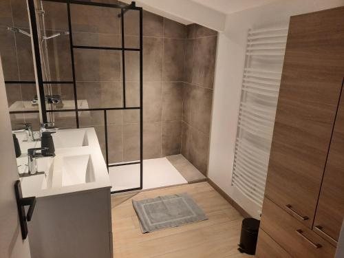 Un baño con ducha, lavabo y espejo. en L'autre Vie, en Bourseul