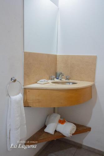 a bathroom with a sink and a mirror at La Laguna - Cabañas de Troncos in Merlo