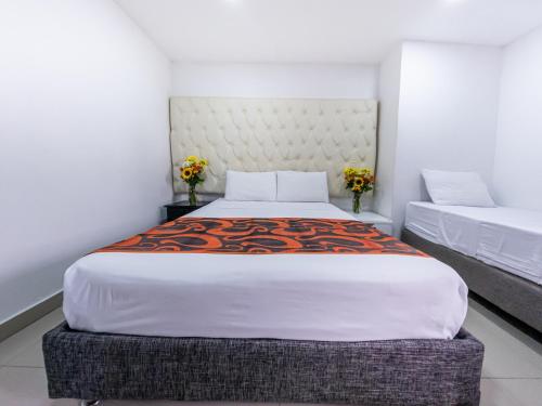 a bedroom with a large bed with a large headboard at Hotel Caribe Plaza Barranquilla in Barranquilla