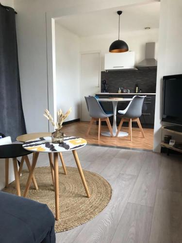 un salon avec une table et des chaises et une cuisine dans l'établissement Duplex à la mer, à Binic