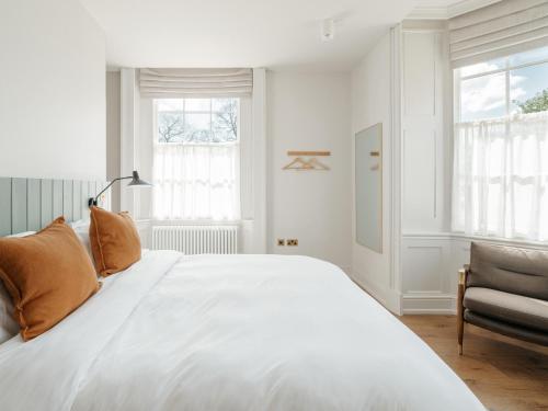 a white bedroom with a large bed and a chair at Constantine House in Tamworth