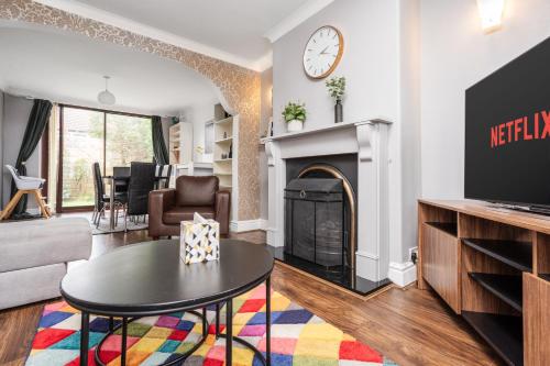 a living room with a fireplace and a tv at Manchester Business and Leisure Home with Free Parking in Manchester