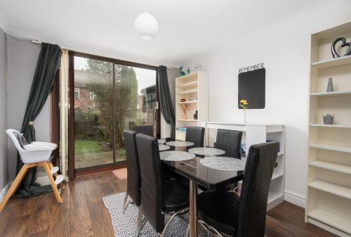 a dining room with a table and chairs and a window at Manchester Business and Leisure Home with Free Parking in Manchester