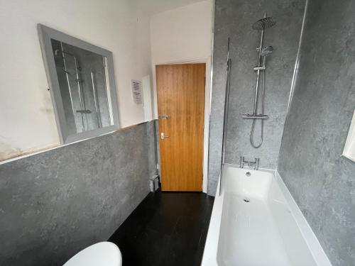ein Badezimmer mit Badewanne, Toilette und Dusche in der Unterkunft The Clifton Guest House in Liverpool