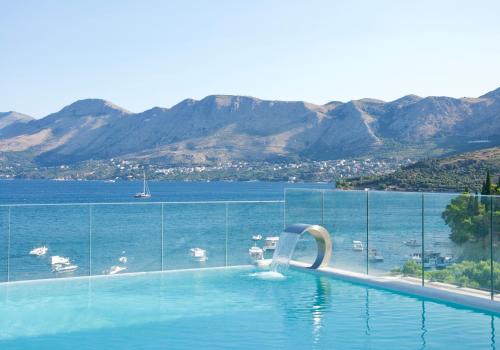 a swimming pool with a view of the water at Hotel Cavtat in Cavtat