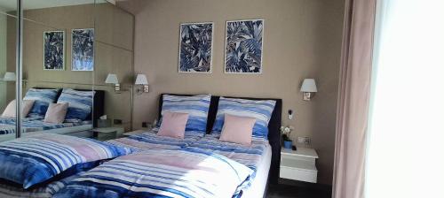 a bedroom with two beds with blue and white sheets at Apartamenty Relaks & Spa Pięć Mórz in Sianozety
