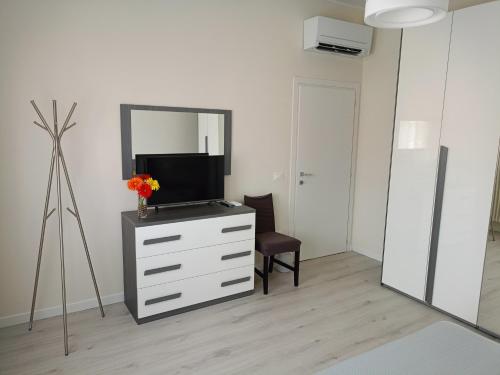 a room with a dresser with a tv and a mirror at Domus Anna in Montegrotto Terme
