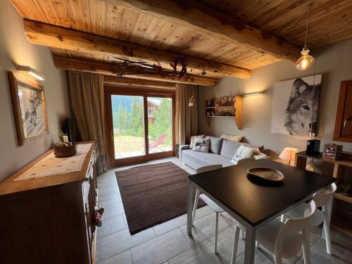 un salon avec une table et un canapé dans l'établissement La Maison de Sofia, à Montgenèvre