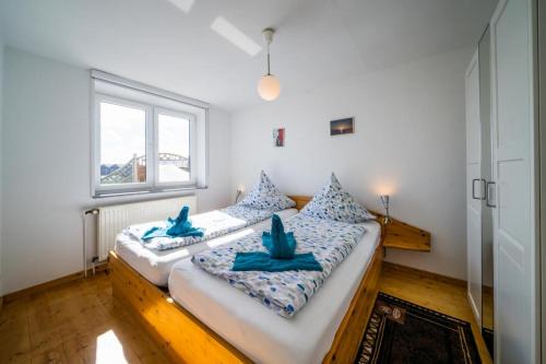ボルクムにあるFerienwohnung Sanddornの青いタオルが付いた客室内のベッド2台
