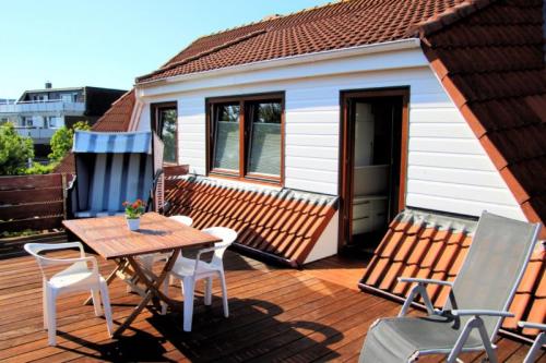 a deck with a table and chairs on a house at Olde Toornblick in Borkum
