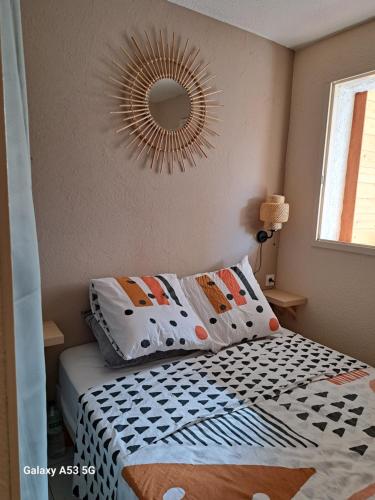 une chambre avec un lit avec un miroir au mur dans l'établissement Appartement t2 cabine de 32m2, au Barcarès