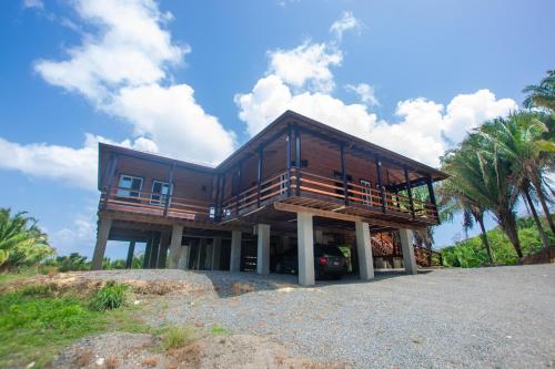 a wooden house with a car parked in front of it at Mountain House Palmetto Bay with Private Pool in Roatan