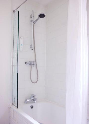 a shower in a bathroom with a white tub at The Coleshill by Greene King Inns in Coleshill