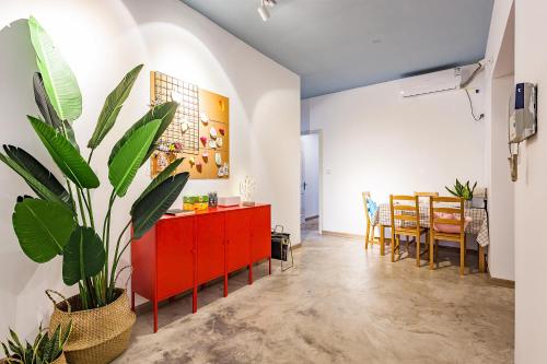 a living room with a red cabinet and a plant at 贰墨民宿南滨路店 in Chongqing