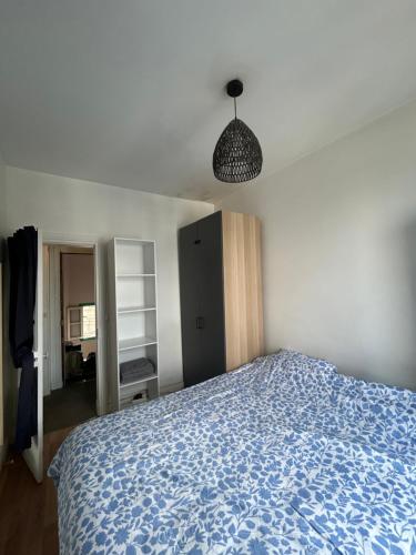 une chambre avec un lit avec une couverture bleue dans l'établissement Appartement Porte de Versailles, à Vanves
