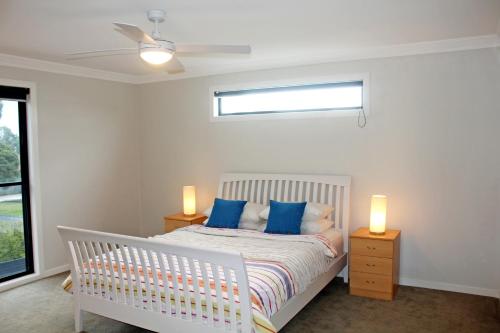 a bedroom with a white crib with blue pillows at Stylish Living- Fireplace, WiFi, Linen, 4 bdrm, Beach 850m in Inverloch