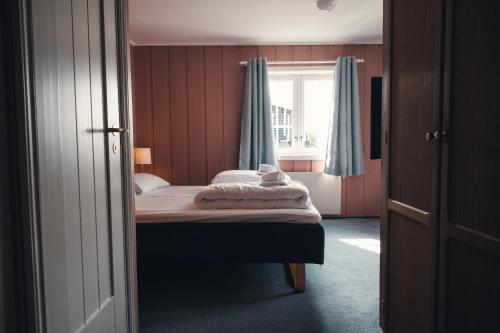 a small bedroom with a bed and a window at Gålå Høgfjellshotell in Gålå